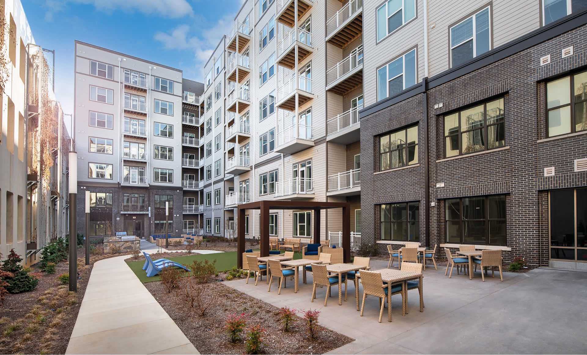 Faraday Park East outdoor courtyard with grills, cabana, and lounge chairs